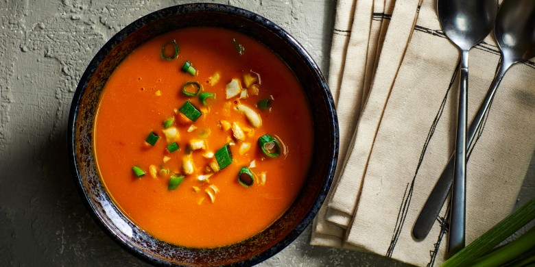 Lichte pompoensoep met tomaat, sambal-olie en cashewnoten 