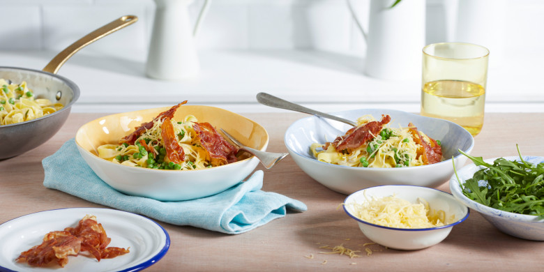 Pasta met roomsaus, doperwten en knapperige parmaham