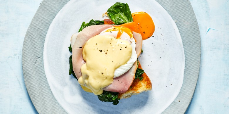 Eggs benedict met ham, spinazie en hollandaisesaus