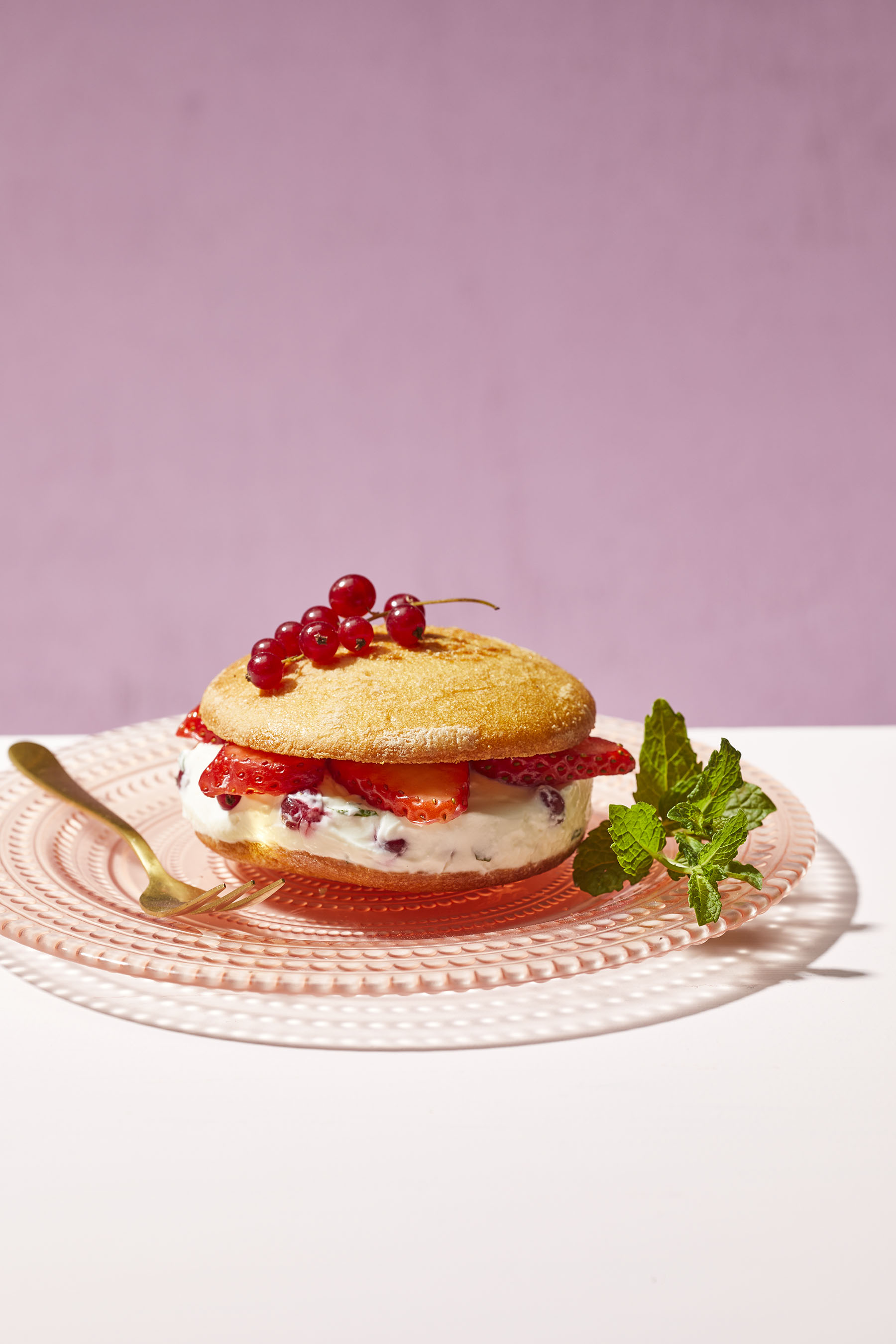 Eierkoeksandwich met aardbeien, rode bessen en muntroom