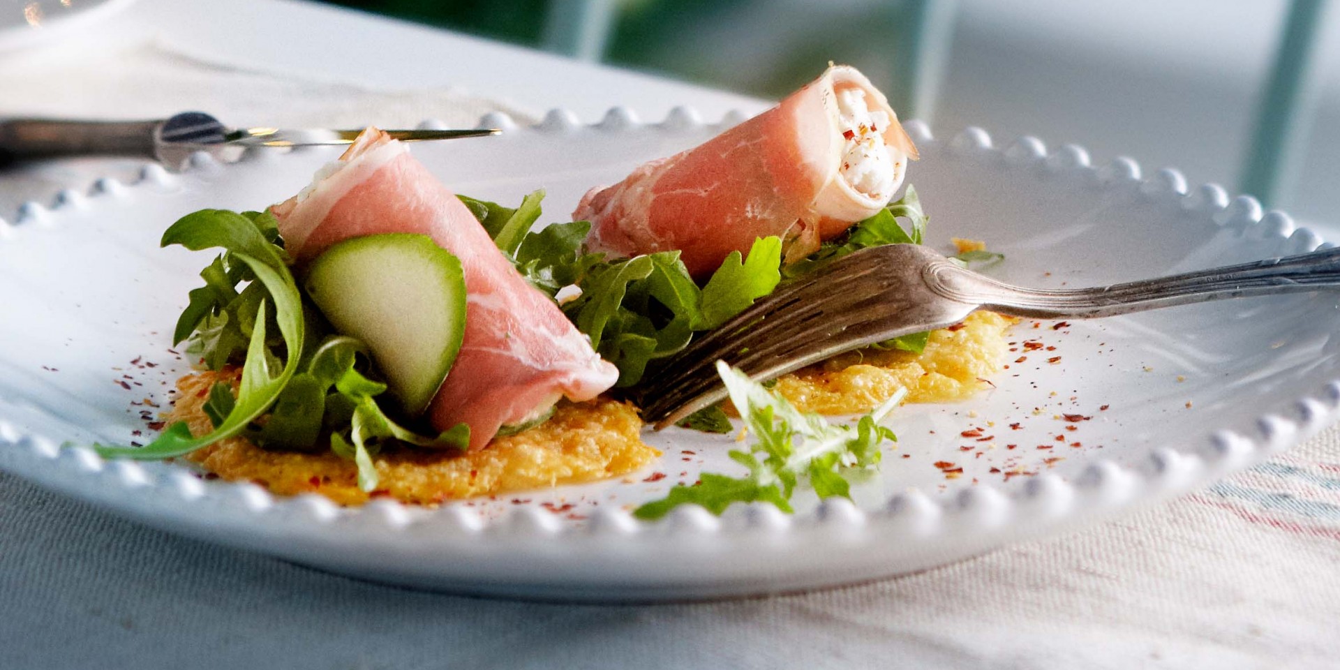 Gevulde parmahamrolletjes op een Parmezaanse-kaascracker