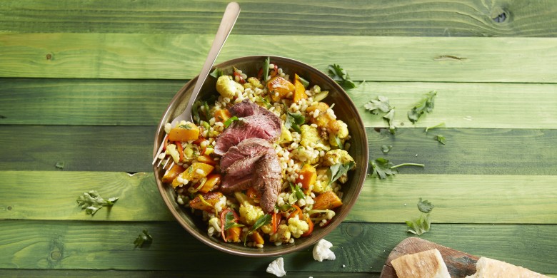 Salade van geroosterde bloemkool en pompoen met parelgort en biefstuk