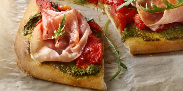 Pizza met rauwe ham, paprika en rucola