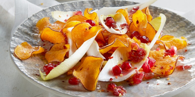 Witlofsalade met peperige zoete-aardappelchips en granaatappeldressing